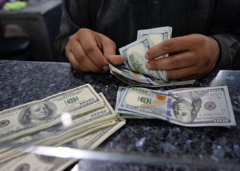 A Pakistani money dealer counts US dollar notes at a currency exchange in Islamabad on March 12, 2014. Pakistan's finance minister Ishaq Dar on March 12 said he was optimistic about an economic recovery after the rupee breached the psychologically important 100 to the dollar mark. The currency had been losing its value against the greenback since Sharif's PML-N government came to power in June last year, sliding from 97 rupees to the dollar to a low of 108 in December. AFP PHOTO/Aamir QURESHI