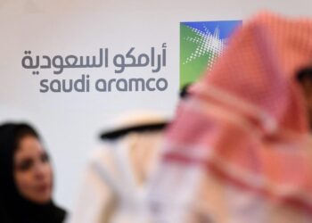 (FILES) In this file photo taken on January 25, 2016 Saudi and Foreign investors stand in front of the logo of Saudi state oil giant Aramco during the 10th Global Competitiveness Forum in the capital Riyadh. – Huthi rebels attacked a facility run by oil company Aramco in Jizan, southern Saudi Arabia, the Saudi-led military coalition fighting the rebels in Yemen said in a statement Saturday.The rebels also hit a desalination plant in Al-Shaqeeq, said the coalition statement, quoted by the Saudi Press Agency (SPA).The coalition said four drones launched into the southern region had been intercepted and destroyed near Yemen. That region is regularly targetted by Huthi drone and missile attacks. (Photo by Fayez Nureldine / AFP)