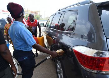 An attendant sell fuel to a motorist at filling stations along Lagos Ibadan expressway, on March 3, 2022. – Petroleum-producing nations are reaping extra revenue since Ukraine’s crisis pushed global oil prices above $100 a barrel, but Nigeria, Africa’s biggest crude producer, is struggling with fuel acarcities that are causing traffic snarks in Lagos and other cities. (Photo by PIUS UTOMI EKPEI / AFP)