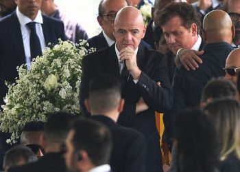 FIFA President Gianni Infantino (C) attends the wake of Brazilian football legend Pele at the Urbano Caldeira stadium in Santos, Sao Paulo, Brazil on January 2, 2023. – Brazilians bid a final farewell this week to football giant Pele, starting Monday with a 24-hour public wake at the stadium of his long-time team, Santos. (Photo by CARL DE SOUZA / AFP)