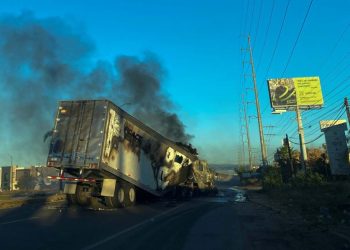 A burning truck is seen across a street during an operation to arrest the son of Joaquin “El Chapo” Guzman, Ovidio Guzman, in Culiacan, Sinaloa state, Mexico, on January 5, 2023. – Intense gunfire rocked a cartel heartland in northwestern Mexico on Thursday after security forces launched an operation in which a son of jailed drug kingpin Joaquin “El Chapo” Guzman was reportedly arrested. (Photo by Marcos Vizcarra / AFP)