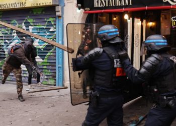 Protester clashes with police during a rally in Paris on January 19, 2023, as workers go on strike over the French President’s plan to raise the legal retirement age from 62 to 64. – A day of strikes and protests kicked off in France on January 19, set to disrupt transport and schooling across the country in a trial for the government as workers oppose a deeply unpopular pensions overhaul. (Photo by Thomas SAMSON / AFP)