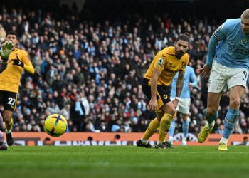 Manchester City’s Norwegian striker Erling Haaland shoots and scores his team third goal during the English Premier League football match between Manchester City and Wolverhampton Wanderers at the Etihad Stadium in Manchester, north west England, on January 22, 2023. (Photo by Paul ELLIS / AFP)