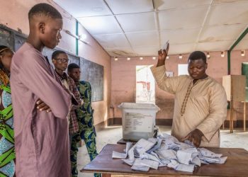 Members of the observers and the CENA (Commission Electorale Nationale Autonome) check the number of votes following the legislative elections at the public primary school, Charles Guillot de Zongo in Cotonou on January 8, 2023. – Benin voted for a new parliament on January 8, 2023 with opposition candidates authorised to stand in the legislative elections for the first time under President Patrice Talon after four years of absence. (Photo by Yanick Folly / AFP)