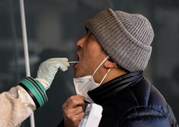 A health worker takes a swab sample from a man to be tested for the Covid-19 coronavirus at a hospital in Beijing on December 26, 2022. (Photo by Noel CELIS / AFP)