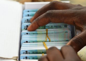 An official of the Independent National Electoral Commission (INEC) sort out Permanent Voters cards (PVC) of voters at a ward in Lagos on January 12, 2023 ahead of February 25 presidential election. (Photo by PIUS UTOMI EKPEI / AFP)