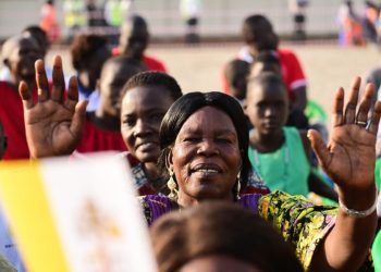 An attendee gestures ahead of Pope Francis’ meeting with bishops, priests, deacons, consecrated persons and seminarians at the Cathedral of Saint Therese in Juba, South Sudan, on February 4, 2023. – Pope Francis will meet South Sudan’s religious leaders, who work with the poor and marginalised and are deeply respected in the devout country where 60 percent of its 12 million people are Christian. (Photo by Tiziana FABI / AFP)