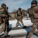 Ukrainian servicemen walk along a street in Siversk on February 17, 2023, amid the Russian invasion of Ukraine. (Photo by YASUYOSHI CHIBA / AFP)