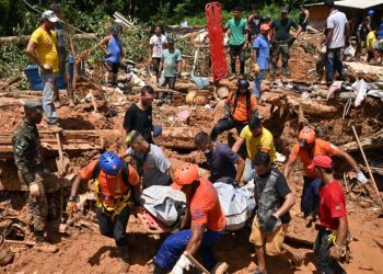 Rescue personnel transport the body of a victim after a flood in Barra do Sahy, Sao Sebastiao district, Sao Paulo state, Brazil on February 21, 2023. – Lifeguards continued to search for survivors on the Sao Paulo coast, where the heaviest rains in Brazil’s history left at least 44 dead and dozens missing over the weekend, authorities said Tuesday. (Photo by NELSON ALMEIDA / AFP)