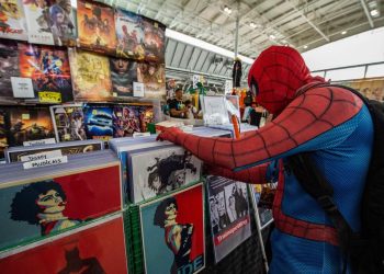 A cosplayer dressed as Spiderman looks through prints for sale during Fan Expo Boston in Boston on August 12, 2022. – Fan Expo Boston is one of the first large-scale comic book and movie conventions to be held in the city since 2019. (Photo by Joseph Prezioso / AFP) (Photo by JOSEPH PREZIOSO/AFP via Getty Images)