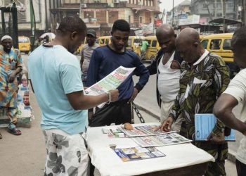 People read newspapers at Tinubu Market in Lagos on February 19, 2023, ahead of the Nigerian presidential election scheduled for February 25, 2023. (Photo by Patrick Meinhardt / AFP)