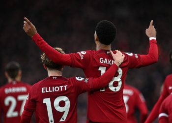 Liverpool’s Dutch striker Cody Gakpo (C) celebrates with Liverpool’s English midfielder Harvey Elliott (L) after scoring the opening goal of the English Premier League football match between Liverpool and Manchester United at Anfield in Liverpool, north west England on March 5, 2023. (Photo by Paul ELLIS / AFP)