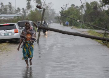 This handout photograph taken and distributed by UNICEF on March 12, 2023 shows a woman walking along a street damaged by the impact of Cyclone Freddy in the city of Quelimane. – Tropical cyclone Freddy, which made landfall in Mozambique overnight from March 11, 2023 to March 12, 2023 for the second time in two weeks, killed at least one person on its return and displaced dozens, according to an initial report from local authorities on March 12, 2023. Freddy had already killed 10 people in the southern African country during his first visit at the end of February and 17 in total in Madagascar where he also struck twice, describing a looping trajectory rarely known to meteorologists. (Photo by Alfredo ZUNIGA / UNICEF / AFP)