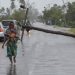 This handout photograph taken and distributed by UNICEF on March 12, 2023 shows a woman walking along a street damaged by the impact of Cyclone Freddy in the city of Quelimane. – Tropical cyclone Freddy, which made landfall in Mozambique overnight from March 11, 2023 to March 12, 2023 for the second time in two weeks, killed at least one person on its return and displaced dozens, according to an initial report from local authorities on March 12, 2023. Freddy had already killed 10 people in the southern African country during his first visit at the end of February and 17 in total in Madagascar where he also struck twice, describing a looping trajectory rarely known to meteorologists. (Photo by Alfredo ZUNIGA / UNICEF / AFP)