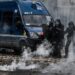 Police officer stand near tear gas during a demonstration, a week after the government pushed a pensions reform through parliament without a vote, using the article 49.3 of the constitution, in Lyon, central France, on March 23, 2023. – French President defiantly vowed to push through a controversial pensions reform on March 22, 2023, saying he was prepared to accept unpopularity in the face of sometimes violent protests. (Photo by JEFF PACHOUD / AFP)