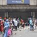 People gather outside a bank in the hope of changing old Nigerian Naira banknotes in Lagos on February 17, 2023. – Nigeria has been struggling with a shortage of hard cash since the Central Bank of Nigeria (CBN) began to swap old bills of the local Naira currency for new, re-designed ones, leading to a shortfall in banknotes.The cash scarcity has triggered protests in major cities as angry customers attacked banks and barricaded roads in unrest just days before Nigeria holds a February 25, 2023 presidential election.Nigerian President Muhammadu Buhari in a February 16, 2023 broadcast sought to ease the scarcity by allowing old 200 naira bills to circulate until April 10. Old 500 and 1,000 notes were no longer legal tender. (Photo by Michele Spatari / AFP) (Photo by MICHELE SPATARI/AFP via Getty Images)