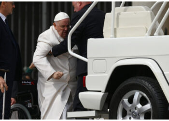 Pope Francis is helped get up the popemobile car as he leaves on March 29, 2023 at the end of the weekly general audience at St. Peter’s square in The Vatican. Pope Francis has been at the Gemelli Hospital in Rome since the afternoon of March 29, 2023 for some previously scheduled check-ups, the Holy See press director said. (Photo by Vincenzo PINTO / AFP)