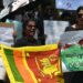 Protestors hold banners and placards during a demonstration against the surge in prices and shortage of fuel and other essential commodities in Colombo on April 4, 2022 – Sri Lanka’s president offered to share power with the opposition on April 4, as protests escalated across the country demanding his resignation over worsening shortages of food, fuel and medicines. (Photo by Ishara S. KODIKARA / AFP)