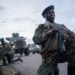 Members of the Uganda Peoples’ Defence Forces (UPDF) position themselves on the Ugandan side of the border town in Bunagana, Democratic Republic of Congo, while awaiting deployment on March 30, 2023. – Democratic Republic of Congo rebels continued to occupy strategic positions in the east of the country late Thursday, the day M23 militants were supposed to withdraw under a regional peace initiative.Among these key sites is the town of Bunagana, on the Ugandan border, where a Ugandan contingent of the Community of East African States (EAC) regional force again delayed their deployment to ensure rebels’ withdrawal. (Photo by Glody MURHABAZI / AFP)