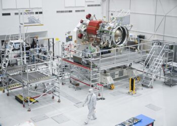 A worker wears a clean room suit as they walk past a propulsion component of the Europa Clipper spacecraft while it is prepared for a mission to Jupiters moon Europa inside a clean room at NASAs Jet Propulsion Laboratory (JPL) in Pasadena, California on April 11, 2023. – In October 2024, NASA will launch the Europa Clipper spacecraft that will study Jupiter’s moon and its underground oceans. (Photo by Patrick T. Fallon / AFP)