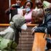 Dr. Nandipha Magudumana (L) speaks with advocate Themba Diba (R) while appearing at the Magistrate’s Court in Bloemfontein on April 13, 2023. Magudumana appears on charges of aiding and abetting fugitive Thabo Bester, who escaped from prison last year unnoticed until recently, whereby he fled the country and was arrested in Tanzania. – A fugitive rapist and murderer who left a burnt corpse in his cell during a daring jailbreak has returned to prison in South Africa after fleeing to Tanzania, officials said Thursday.The case has embarrassed authorities and sparked fresh outrage over the competence of South Africa’s police and criminal justice system. (Photo by – / AFP)