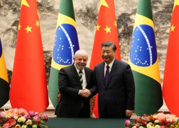 Chinese President Xi Jinping (R) and Brazil’s President Luiz Inacio Lula da Silva shake hands after a signing ceremony at the Great Hall of the People in Beijing on April 14, 2023. (Photo by Ken Ishii / POOL / AFP)