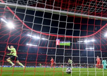 Manchester City’s Norwegian striker Erling Haaland (L) celebrates after scoring the 0-1 opening goal against Bayern Munich’s Swiss goalkeeper Yann Sommer (R) during the UEFA Champions League quarter-final, second leg football match between Bayern Munich and Manchester City in Munich, southern Germany on April 19, 2023. (Photo by CHRISTOF STACHE / AFP)