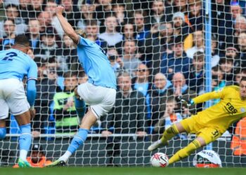 Manchester City’s Norwegian striker Erling Haaland (C) shoots a penalty kick and scores his team second goal during the English Premier League football match between Manchester City and Leicester City at the Etihad Stadium in Manchester, north west England, on April 15, 2023. (Photo by Lindsey Parnaby / AFP)