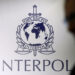 FILE PHOTO: A man passes an Interpol logo during the handing over ceremony of the new premises for Interpol’s Global Complex for Innovation, a research and development facility, in Singapore September 30, 2014. REUTERS/Edgar Su/File Photo