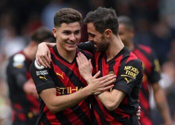 Manchester City's Argentinian striker Julian Alvarez (L) and Manchester City's Portuguese midfielder Bernardo Silva (R) celebrate on the pitch after the English Premier League football match between Fulham and Manchester City at Craven Cottage in London on April 30, 2023. - Man City won the game 2-1. (Photo by Adrian DENNIS / AFP) / RESTRICTED TO EDITORIAL USE. NO USE WITH UNAUTHORIZED AUDIO, VIDEO, DATA, FIXTURE LISTS, CLUB/LEAGUE LOGOS OR 'LIVE' SERVICES. ONLINE IN-MATCH USE LIMITED TO 120 IMAGES. AN ADDITIONAL 40 IMAGES MAY BE USED IN EXTRA TIME. NO VIDEO EMULATION. SOCIAL MEDIA IN-MATCH USE LIMITED TO 120 IMAGES. AN ADDITIONAL 40 IMAGES MAY BE USED IN EXTRA TIME. NO USE IN BETTING PUBLICATIONS, GAMES OR SINGLE CLUB/LEAGUE/PLAYER PUBLICATIONS. - RESTRICTED TO EDITORIAL USE. No use with unauthorized audio, video, data, fixture lists, club/league logos or 'live' services. Online in-match use limited to 120 images. An additional 40 images may be used in extra time. No video emulation. Social media in-match use limited to 120 images. An additional 40 images may be used in extra time. No use in betting publications, games or single club/league/player publications. /