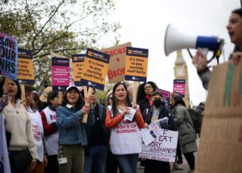 Healthcare workers hold placards as they demonstrate on Westminster Bridge, near to St Thomas’ Hospital in London on May 1, 2023, as members of the Royal College of Nursing (RCN) continue their industrial action. – Nurses in England and Wales were forced Thursday to cancel part of an upcoming strike after a High Court judge ruled it would be unlawful. Royal College of Nursing (RCN) general secretary Pat Cullen said they would press ahead with planned industrial action starting late Sunday and continuing Monday. (Photo by Daniel LEAL / AFP)