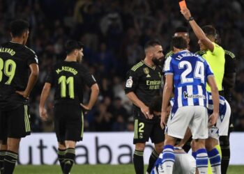 Spanish referee Pulido Santana presents a red card to Real Madrid’s Spanish defender Dani Carvajal (3L) during the Spanish league football match between Real Sociedad and Real Madrid CF at the Reale Arena stadium in San Sebastian on May 2, 2023. (Photo by ANDER GILLENEA / AFP)