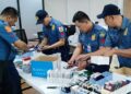 This handout photo taken on May 4, 2023 and received from the Philippine National Police anti-Cybercrime group on May 6 shows policemen inspecting documents and passports after a raid inside a freeport zone in Mabalacat City, in Pampanga province, north of Manila. – Philippine authorities have rescued over a thousand people from several Asian countries who were trafficked into the country and forced to run online scams, an official said on May 6. (Photo by Handout / Philippine National Police Anti-Cybercrime Group / AFP) / —–EDITORS NOTE — RESTRICTED TO EDITORIAL USE – MANDATORY CREDIT “AFP PHOTO