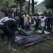 Congolese Red Cross volunteers and residents of Nyamukubi wrap in blankets the bodies of people who died in heavy flooding in eastern Democratic Republic of Congo, on May 6, 2023. – Heavy rainfall in the Kalehe region of South Kivu province on Thursday caused rivers to overflow, causing landslides that engulfed the villages of Bushushu and Nyamukubi. The death toll from floods and landslides triggered by heavy rain in the east of the Democratic Republic of Congo has risen to nearly 400, an official said on Sunday. (Photo by Glody MURHABAZI / AFP)