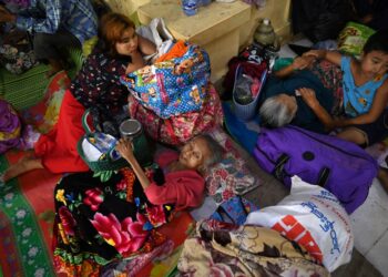 People shelter at a monastery in Sittwe in Myanmar’s Rakhine state on May 13, 2023, ahead of the expected landfall of Cyclone Mocha. – Cyclone Mocha is expected to make landfall on May 14 between Cox’s Bazar in Bangladesh, where nearly one million Rohingya refugees live in camps largely made up of flimsy shelters, and Sittwe on Myanmar’s western Rakhine coast. (Photo by SAI Aung MAIN / AFP)