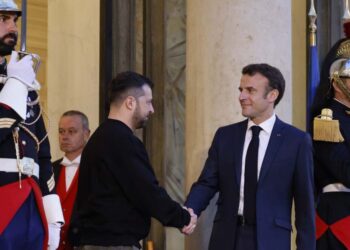 Ukraine’s President Volodymyr Zelensky (C,L) is welcomed by France’s President Emmanuel Macron (C,R) upon his arrival at the Elysee presidential palace in Paris on May 14, 2023. – Ukraine’s President Volodymyr Zelensky landed in Paris for talks with French President Emmanuel Macron, after accepting a prize for his country’s fight for “European ideals” during a visit to Germany. (Photo by Ludovic MARIN / AFP)