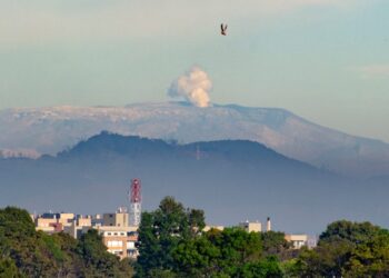 The Nevado del Ruiz volcano emits a cloud of ash as seen from Bogota, on May 18, 2023. – The 5,300-metre (17,400-foot) colossus in western Colombia is one of the many volcanoes along the Ring of Fire, a path around the Pacific basin characterized by active volcanoes and frequent earthquakes. The rumbling, notorious volcano has been showing increased seismic activity in the past weeks. (Photo by Guillermo MUNOZ / AFP)