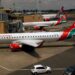 FILE PHOTO: Kenya Airways planes are seen through a window as the Jomo Kenyatta international airport reopens after flights were suspended following the coronavirus disease (COVID-19) outbreak in Nairobi, Kenya August 1, 2020. REUTERS/Njeri Mwangi/File Photo