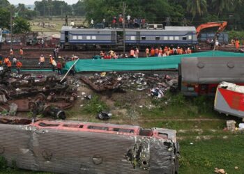 Railway workers help to restore services at the accident site of a three-train collision near Balasore, about 200 km (125 miles) from the state capital Bhubaneswar in the eastern state of Odisha, on June 4, 2023. – Railway teams worked non-stop on June 4 restoring tracks after India’s deadliest train crash in decades, a tragedy that has reignited safety concerns about one of the largest networks in the world. (Photo by Punit PARANJPE / AFP)