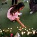 A youth lights candles at a playground in the “Jardins de l’Europe” in Annecy, in the French Alps, on June 8, 2023, following a mass stabbing in the park of the city. (Photo by OLIVIER CHASSIGNOLE / AFP)