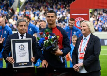 Portugal’s forward Cristiano Ronaldo (C) is honoured with a certificate of the Guinness World Records for having achieved 200 goals within almost 20 years of his career, prior to the UEFA Euro 2024 group J qualification football match between Iceland and Portugal in Reykjavik on June 20, 2023. (Photo by Halldor KOLBEINS / AFP)