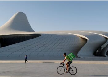 A Bolt Food delivery courier rides a bicycle outside the Heydar Aliyev Center in Baku, Azerbaijan June 18,