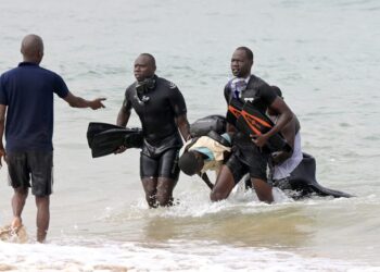 EDITORS NOTE: Graphic content / Senegalese rescue personnel remove a body of a victim from the ocean in Ouakam, in Dakar on July 24, 2023 after a boat capsized off the coast of Dakar. – At least 14 people died after their wooden boat capsized off the Senegalese capital Dakar, a district deputy mayor told AFP on July 24, 2023. (Photo by SEYLLOU / AFP)