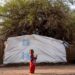 An internally displaced child stands outside a tent pitched at the Hasahisa secondary school on July 10, 2023, which has been made into a make-shift camp to house those fleeing violence in war-torn Sudan. – Conflict-torn Sudan is on the brink of a “full-scale civil war” that could destabilise the entire region, the United Nations warned on July 9, after an air strike on a residential area killed around two dozen civilians. (Photo by – / AFP)