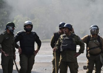 Policemen stand guard as Pakistan Tehreek-e-Insaf (PTI) party activists and supporters of former Pakistan’s Prime Minister Imran Khan protest against the arrest of their leader, in Lahore on May 10, 2023. (Photo by Arif ALI / AFP) / The erroneous mention[s] appearing in the metadata of this photo by Arif ALI has been modified in AFP systems in the following manner: [May 10, 2023] instead of [May 11, 2023]. Please immediately remove the erroneous mention[s] from all your online services and delete it (them) from your servers. If you have been authorized by AFP to distribute it (them) to third parties, please ensure that the same actions are carried out by them. Failure to promptly comply with these instructions will entail liability on your part for any continued or post notification usage. Therefore we thank you very much for all your attention and prompt action. We are sorry for the inconvenience this notification may cause and remain at your disposal for any further information you may require.