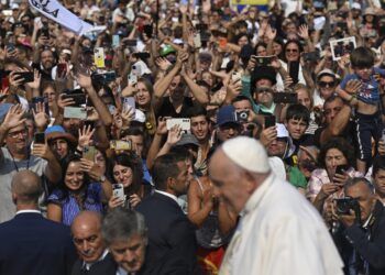 Pilgrims wave to Pope Francis as he departs the Sanctuary of Our Lady of Fatima, in Fatima, on August 5, 2023. – Around one million pilgrims from all over the world will attend the World Youth Day, the largest Catholic gathering in the world, created in 1986 by John Paul II. (Photo by Patricia DE MELO MOREIRA / AFP)