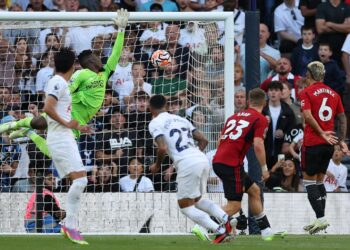 Manchester United’s Cameroonian goalkeeper #24 Andre Onana (back 2ndL) jumps for the ball as it hits the bar after a kick by Tottenham Hotspur’s Spanish defender #23 Pedro Porro (C) during the English Premier League football match between Tottenham Hotspur and Manchester United at Tottenham Hotspur Stadium in London, on August 19, 2023. (Photo by Adrian DENNIS / AFP)