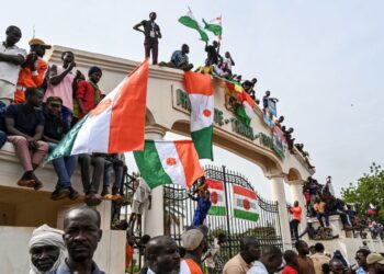 Supporters of Niger’s National Concil of Sefeguard of the Homeland (CNSP) hold Niger national flags during as they gather at Place de la Concertation in Niamey on August 20, 2023. (Photo by – / AFP)