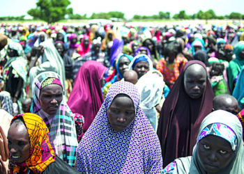 women and children queue to enter one of the Unicef nutrition clinics at the Muna makeshift camp which houses more than 16,000 IDPs (internaly displaced people) on the outskirts of Maiduguri, Borno State, northeastern Nigeria./ AFP PHOTO / STEFAN HEUNIS