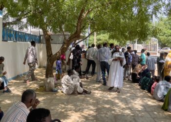 People queue outside a Passports and Immigration Services office in Wad Madani on September 3, 2023, following an announcement by the authorities of the resumption of issuing travel documents in war-torn Sudan. (Photo by – / AFP)